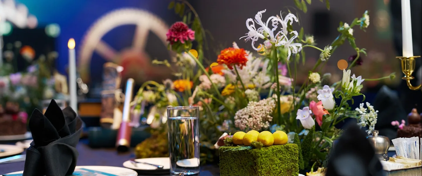 A dining table dressed with flowers and fruit