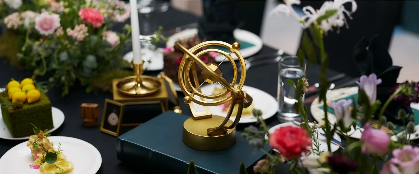 A gold armillary sphere centrepiece among the flowers