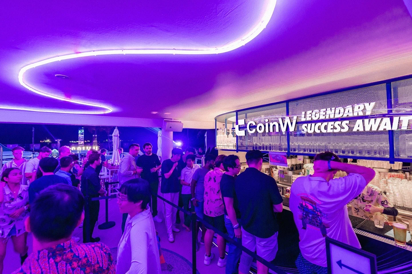Guests at the bar under a neon wave, with the Legendary success awaits sign