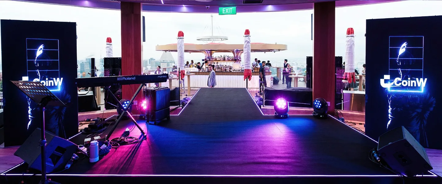 The stage set with CoinW screens at dusk